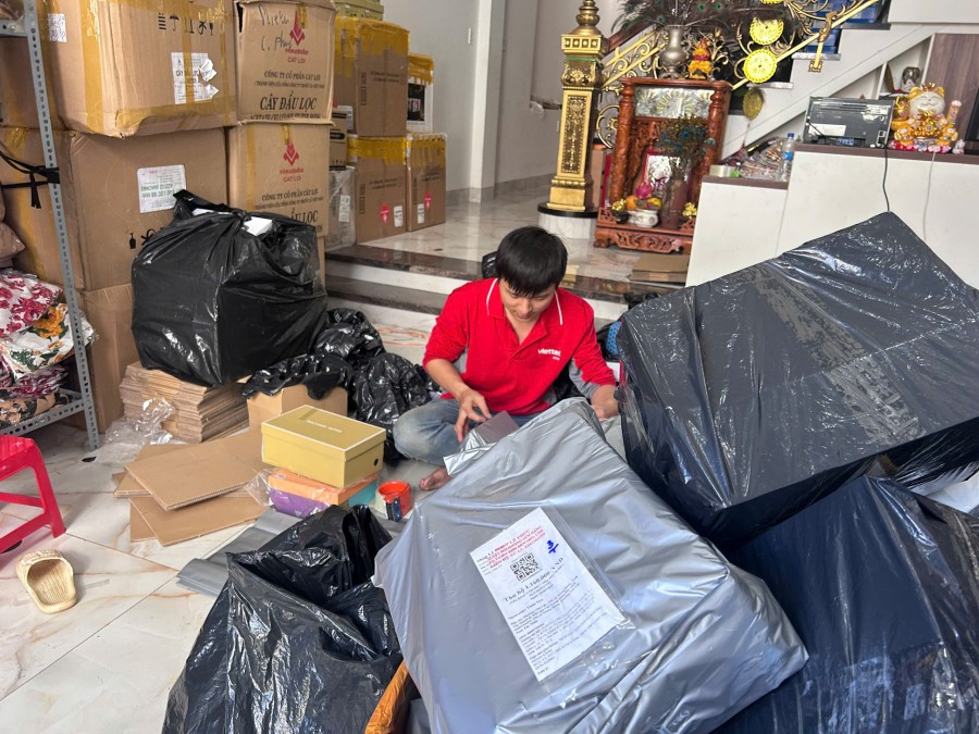 Bưu tá Hoàng Trung tỉ mỉ kiểm tra, đánh dấu từng đơn hàng để tối ưu thời gian giao hàng của mình